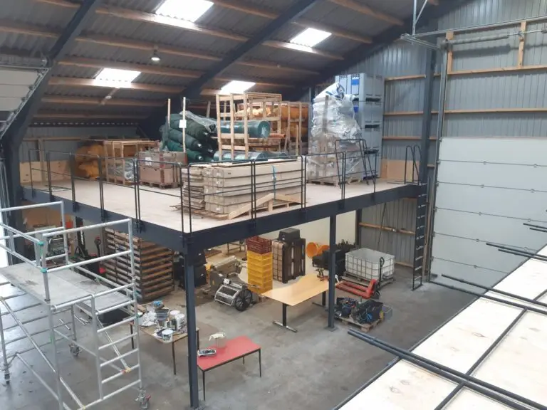 Højlagerkonstruktion i rustfrit stål med rækværk og adgangsstige monteret i industribygning