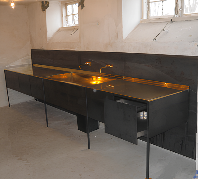 Køkken i valseblå stålplade med integreret messing bordplade og vask