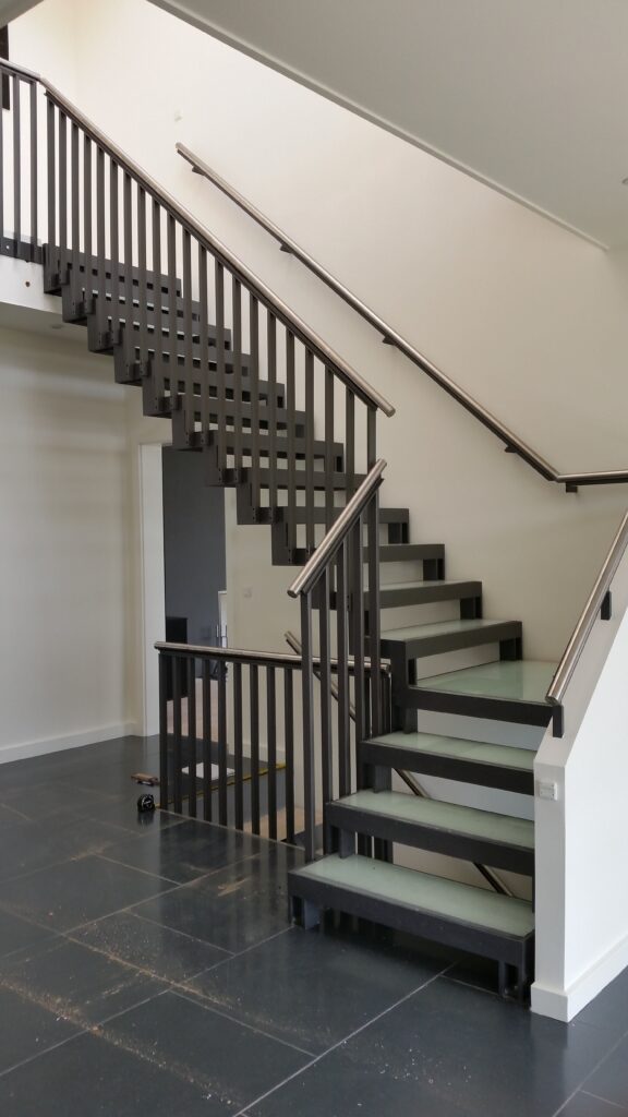 Indvendig ståltrappe med glastrin og rustfri håndliste